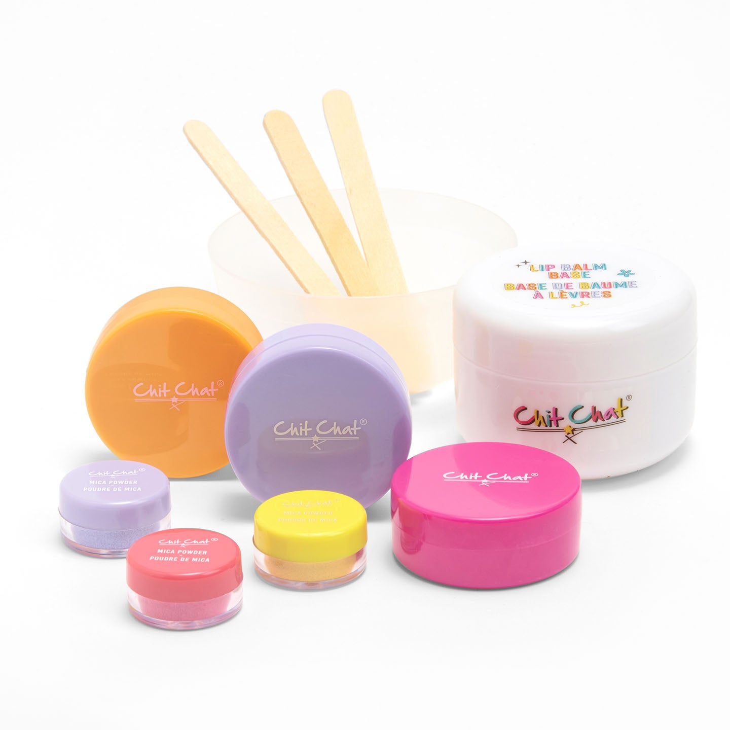 Set of colourful lip balm containers with mixing bowl and sticks on a white background